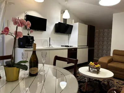 a living room with a glass table and a bottle of wine at Cosy apartment in Kaunas