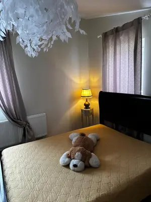 a teddy bear laying on top of a bed at Cosy apartment in Kaunas