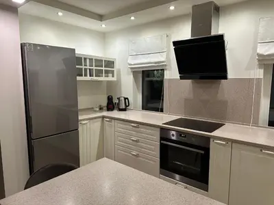 a kitchen with a refrigerator and a stove top oven at Apartamentai in Marijampolė