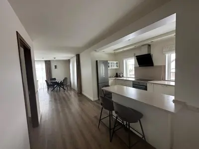 a kitchen with a counter and chairs in a room at Apartamentai in Marijampolė