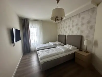 a bedroom with two beds and a window at Apartamentai in Marijampolė