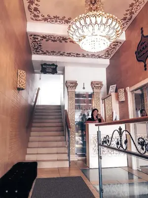 a staircase with a chandelier and a woman in a store at Baltazaras in Vilnius