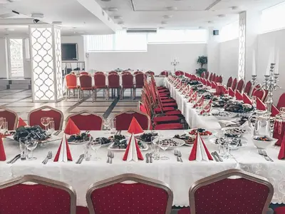 a banquet hall with tables and red chairs at Baltazaras in Vilnius