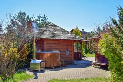 a wooden cabin with a hot tub in a yard at Aerodream Trakai in Antakalnis