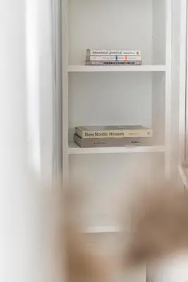a book shelf with books sitting on it at Bali style apartment with balcony near Gates of Dawn in Vilnius