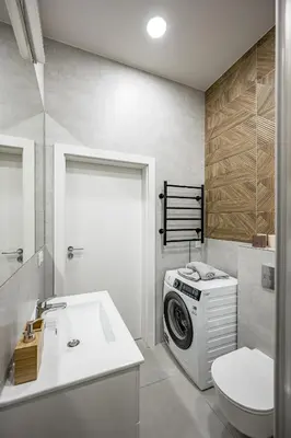 a bathroom with a washing machine and a toilet at Bali style apartment with balcony near Gates of Dawn in Vilnius