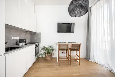 a kitchen with a table and chairs in a room at Bali style apartment with balcony near Gates of Dawn in Vilnius