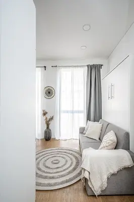 a living room with a couch and a window at Bali style apartment with balcony near Gates of Dawn in Vilnius