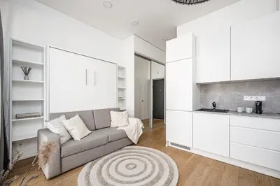 a living room with a couch and a kitchen at Bali style apartment with balcony near Gates of Dawn in Vilnius