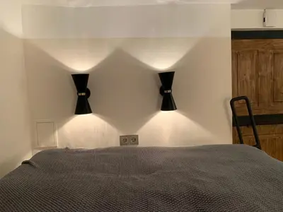 a bedroom with two black lights on the wall at CLASSY PLACE IN VILNIUS CENTER FOR TWO in Vilnius