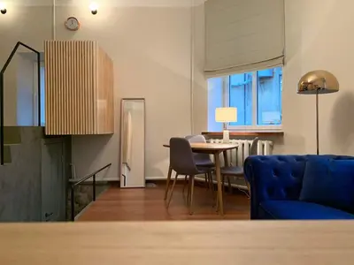 a living room with a blue couch and a table at CLASSY PLACE IN VILNIUS CENTER FOR TWO in Vilnius