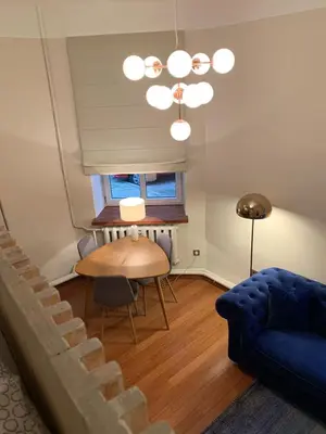 a living room with a table and a blue couch at CLASSY PLACE IN VILNIUS CENTER FOR TWO in Vilnius