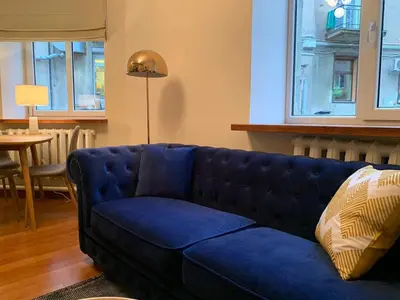 a blue couch in a living room with a table at CLASSY PLACE IN VILNIUS CENTER FOR TWO in Vilnius