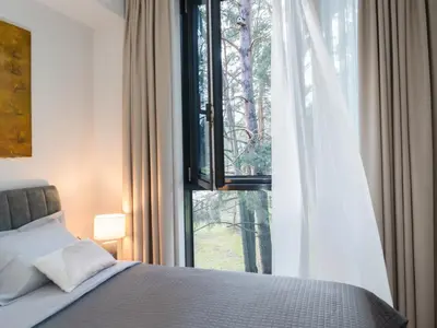 a bedroom with a bed and a large window at Butique Apartamentai Birštone - Holistic Skin & Wellness SPA Apartments - Inovatyvios dermatologijos centras in Birštonas