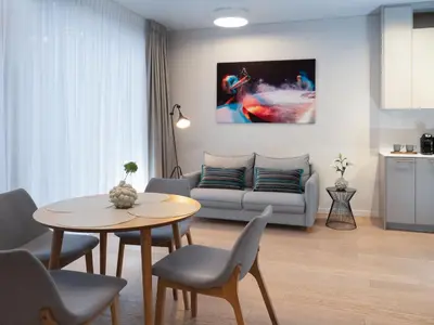 a living room with a table and a couch at Butique Apartamentai Birštone - Holistic Skin & Wellness SPA Apartments - Inovatyvios dermatologijos centras in Birštonas