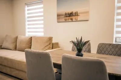 a dining room with a table and a couch at Senamiesčio apartamentai in Anykščiai