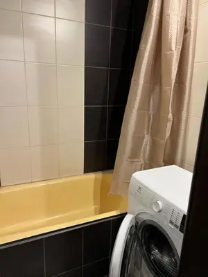 a washing machine in a bathroom with a tub at 2 kambarių butas Alytuje in Alytus