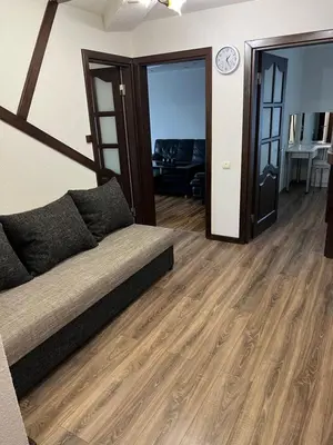 a living room with a couch and wooden floors at 2 kambarių butas Alytuje in Alytus