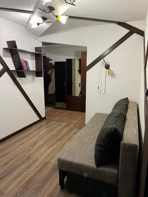 a living room with a couch and a mirror at 2 kambarių butas Alytuje in Alytus
