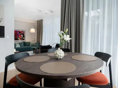 a dining room with a table and chairs at Butique Apartamentai Birštone - Holistic Skin & Wellness SPA Apartments - Inovatyvios dermatologijos centras in Birštonas