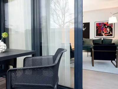 a room with a chair and a living room at Butique Apartamentai Birštone - Holistic Skin & Wellness SPA Apartments - Inovatyvios dermatologijos centras in Birštonas