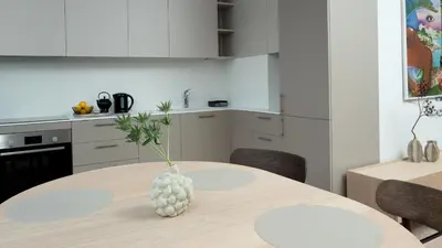 a kitchen with a table with a vase on it at Butique Apartamentai Birštone - Holistic Skin & Wellness SPA Apartments - Inovatyvios dermatologijos centras in Birštonas