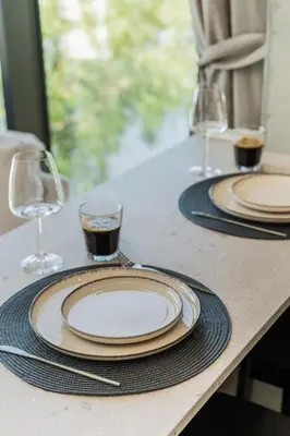 two plates and wine glasses on a table at Kaunorama Riverside Suite in Kaunas