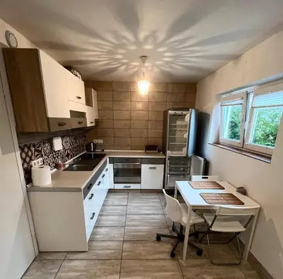 a kitchen with white cabinets and a table in it at HELLO House in Alytus