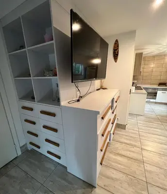 a living room with a tv on top of a dresser at HELLO House in Alytus