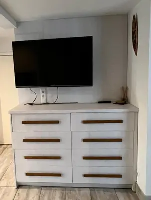 a white dresser with a flat screen tv on top of it at HELLO House in Alytus