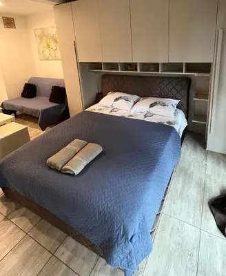 a bedroom with a large bed with a blue blanket at HELLO House in Alytus