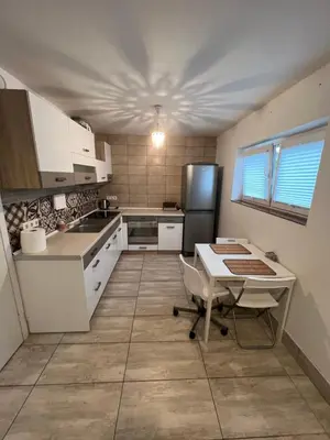 a kitchen with a table and a refrigerator at HELLO House in Alytus