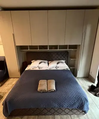 a bedroom with a bed with two towels on it at HELLO House in Alytus