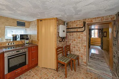 a kitchen with a stove and a chair in it at Spacious Studio apartment by Polo apartments in Kaunas