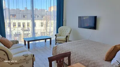a hotel room with a bed and a couch and a tv at KaunasInn LA in Kaunas