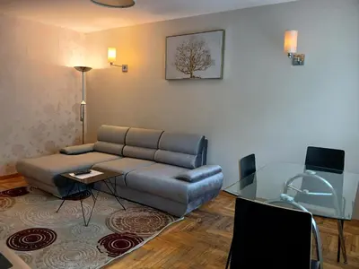 a living room with a couch and a glass table at Butas su Jacuzzi in Kaunas