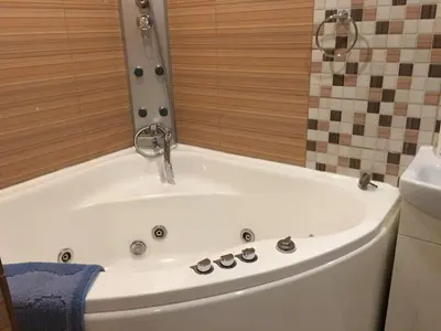 a white bath tub with a faucet in a bathroom at Butas su Jacuzzi in Kaunas