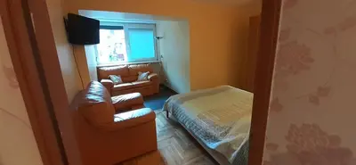 a living room with a couch and a bed and a window at Butas su Jacuzzi in Kaunas