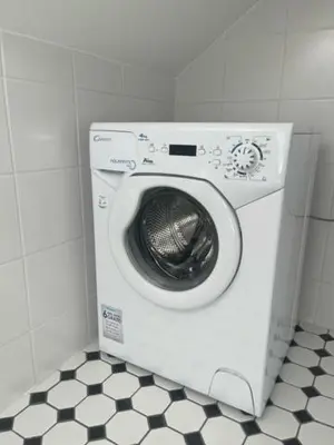 a washing machine in a bathroom with a tiled floor at Luxury Central Apartment Easy Kaunas in Kaunas