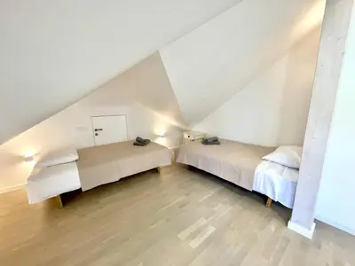 two beds in a attic room with white walls at Luxury Central Apartment Easy Kaunas in Kaunas