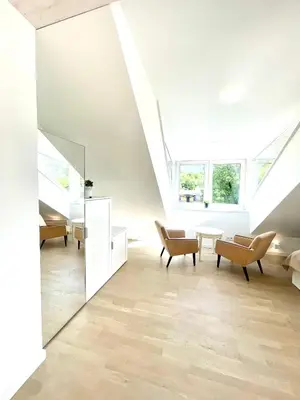 a living room with white walls and a vaulted ceiling at Luxury Central Apartment Easy Kaunas in Kaunas