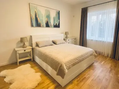 a bedroom with a white bed and a window at Luxury Central Apartment Easy Kaunas in Kaunas