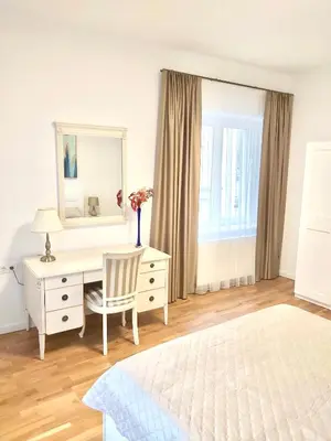 a bedroom with a bed and a desk and a mirror at Luxury Central Apartment Easy Kaunas in Kaunas