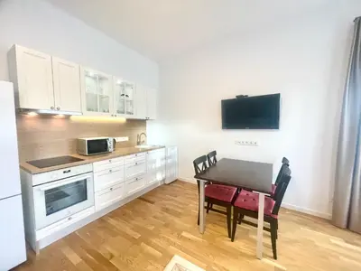 a kitchen with a dining table and a microwave at Luxury Central Apartment Easy Kaunas in Kaunas