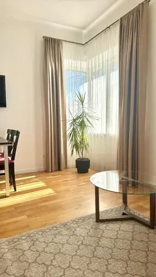 a living room with a glass table and a window at Luxury Central Apartment Easy Kaunas in Kaunas