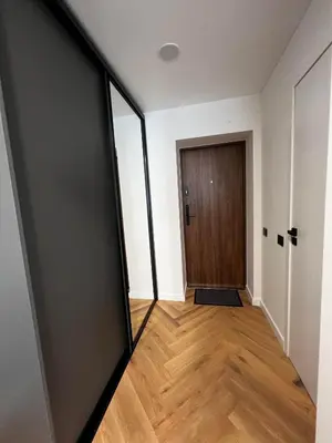 an empty room with a door and a wooden floor at Hygge Apartments in Druskininkai