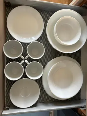 a bunch of white plates sitting on a shelf at Barbacan Apartments in the Old Town in Vilnius