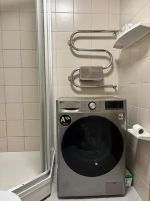 a washing machine in a bathroom with a shower at Barbacan Apartments in the Old Town in Vilnius