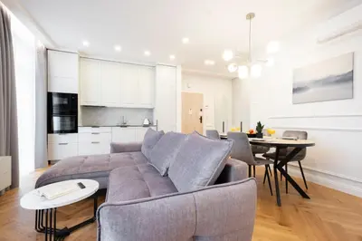 a living room and kitchen with a couch and a table at 2BD,Terrace, AC, next to Dineika Park, Brand NEW, by Cohost in Druskininkai