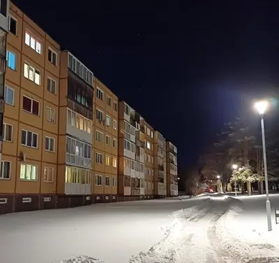 a snow covered street in front of a building at Quiet apartment near park SELF CHECK IN in Šiauliai
